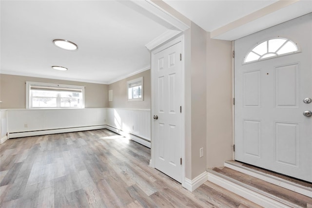 entrance foyer featuring plenty of natural light, ornamental molding, and light hardwood / wood-style floors