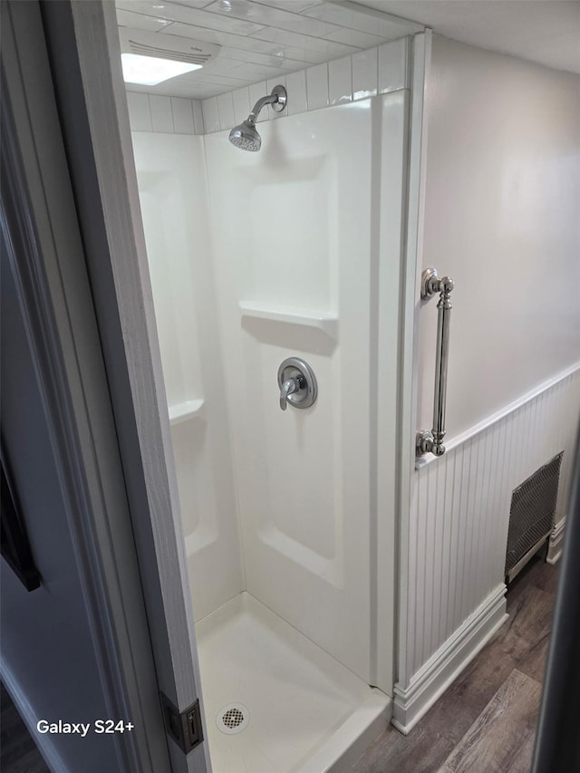 bathroom with walk in shower and hardwood / wood-style flooring