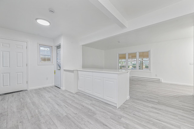 interior space with baseboard heating, beam ceiling, and light wood-type flooring