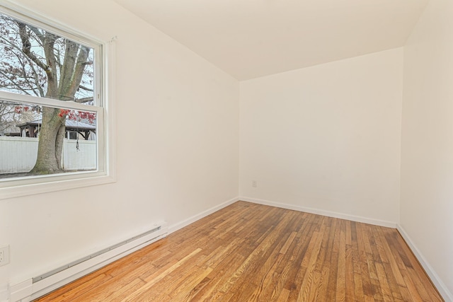 empty room with baseboard heating and hardwood / wood-style flooring