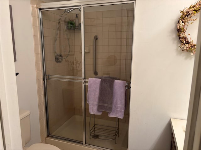 bathroom featuring toilet, vanity, and walk in shower