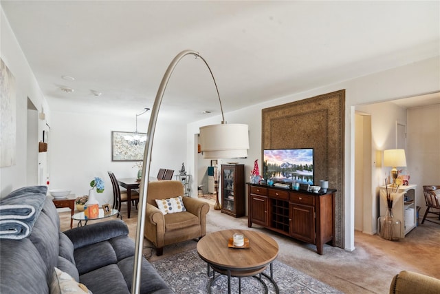 living area featuring a chandelier and light carpet