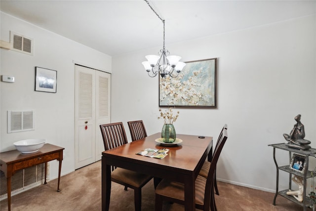 carpeted dining area featuring baseboards, visible vents, and a notable chandelier