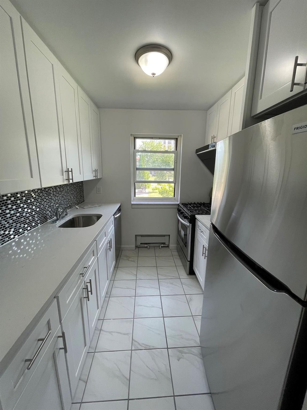 kitchen with sink, white cabinets, and stainless steel appliances