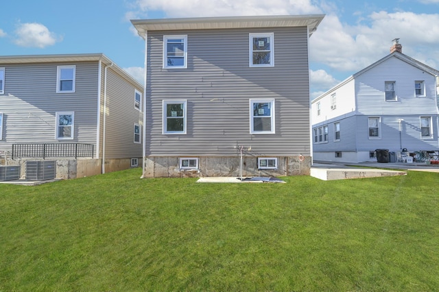 back of property with a lawn and central AC unit