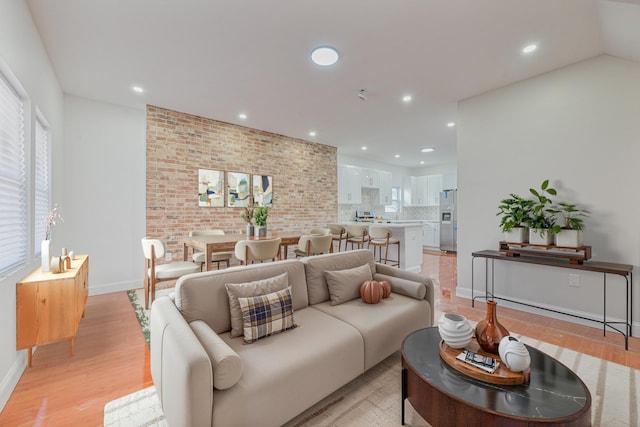 living room featuring light hardwood / wood-style floors and brick wall