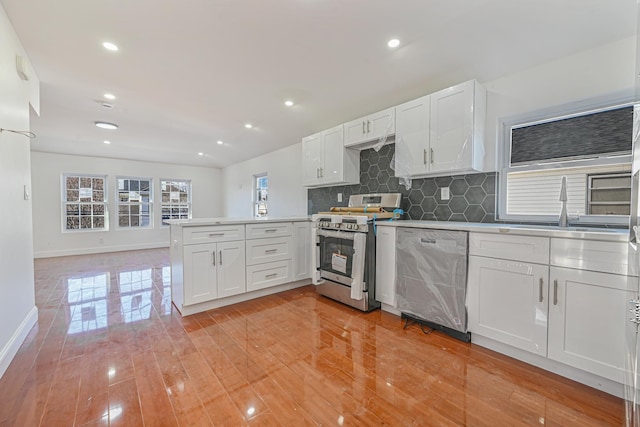 kitchen featuring sink, kitchen peninsula, white cabinets, and stainless steel appliances