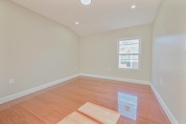 empty room featuring light wood-type flooring and lofted ceiling