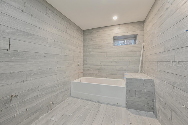 bathroom with tile walls and a tub to relax in