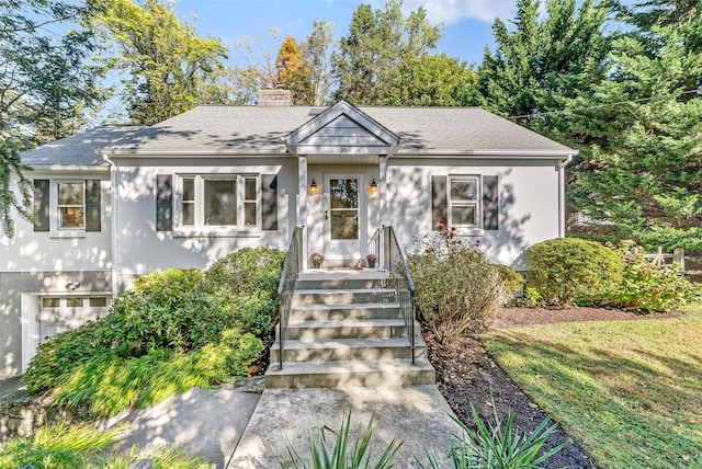 view of front of house featuring a shingled roof and a chimney