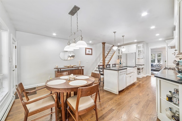 dining room with recessed lighting, a baseboard heating unit, baseboards, stairway, and light wood finished floors