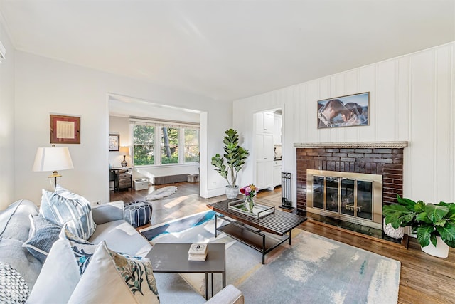 living area featuring a brick fireplace and wood finished floors