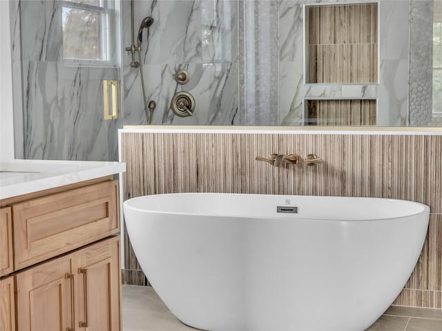 bathroom featuring independent shower and bath, tile patterned floors, tile walls, and vanity