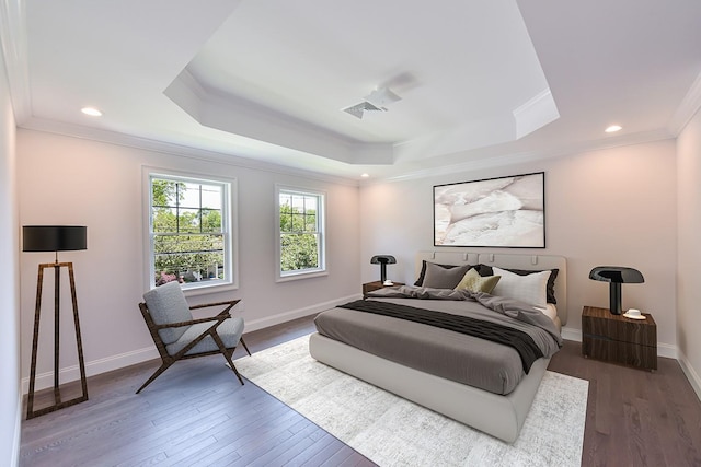 bedroom featuring crown molding, dark wood-type flooring, and a tray ceiling