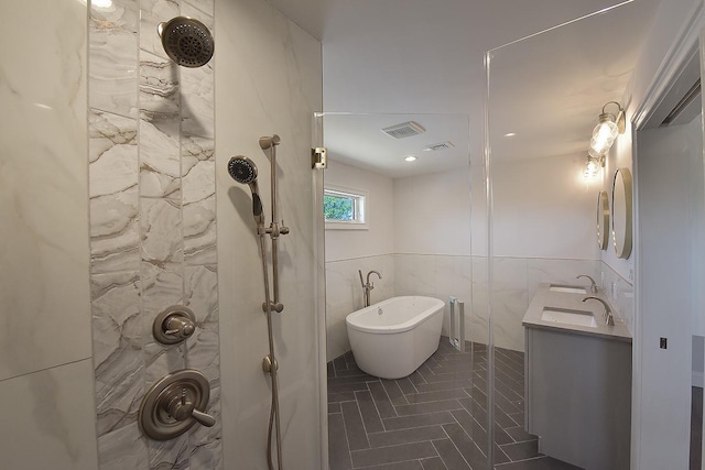 bathroom featuring vanity, tile walls, tile patterned flooring, and plus walk in shower