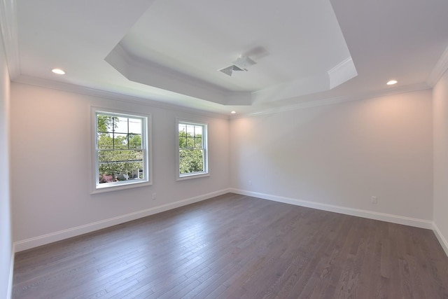 unfurnished room with a tray ceiling, dark hardwood / wood-style floors, and crown molding