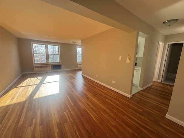 spare room featuring radiator and dark hardwood / wood-style flooring