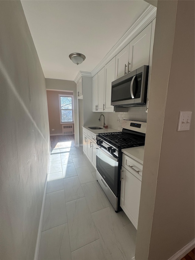 kitchen featuring tasteful backsplash, white cabinets, sink, and stainless steel appliances