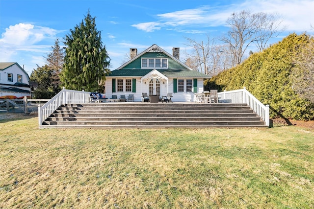 rear view of house with a wooden deck and a lawn