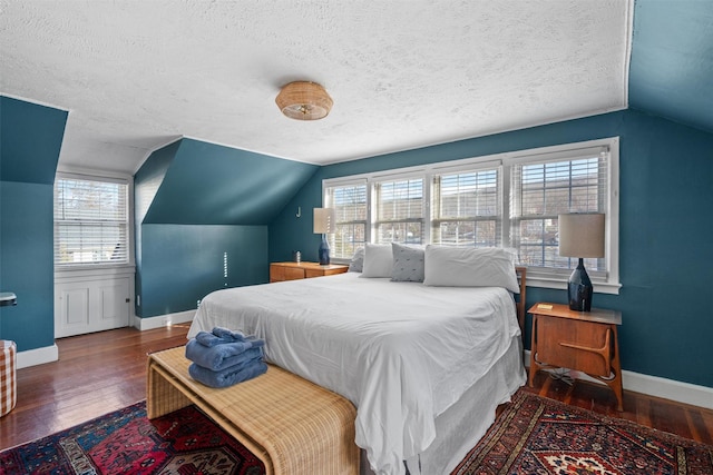 bedroom featuring lofted ceiling, dark wood-type flooring, and a textured ceiling