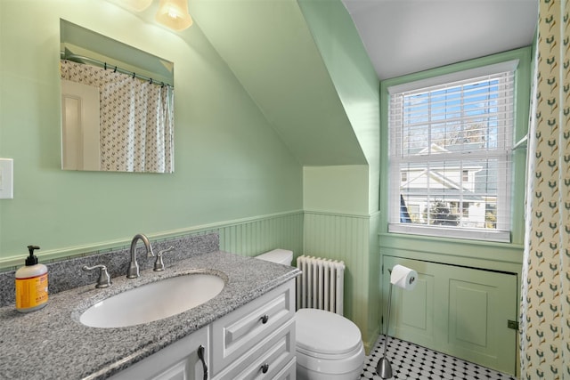 bathroom featuring radiator, lofted ceiling, vanity, toilet, and walk in shower