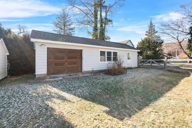 view of front of home featuring a front yard, a garage, and an outdoor structure