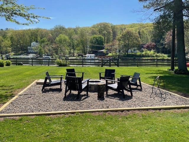 view of property's community featuring a fire pit and a lawn