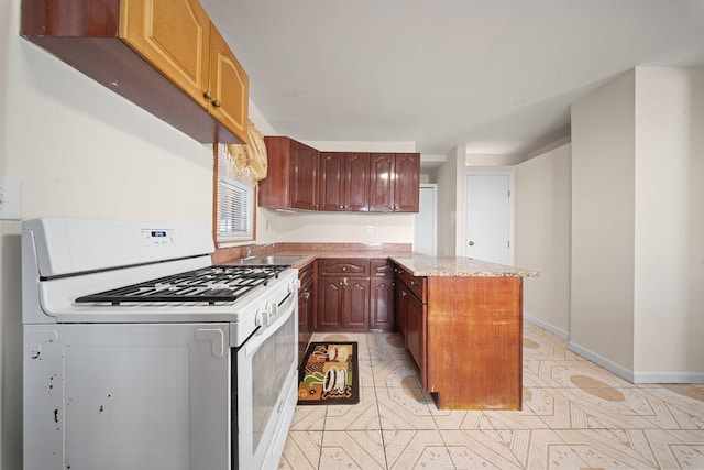 kitchen with a center island, white gas range, sink, and light tile patterned flooring