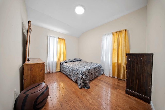 bedroom with vaulted ceiling and light hardwood / wood-style floors