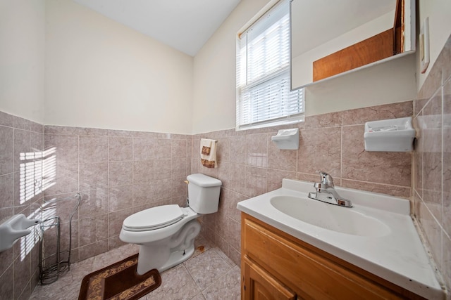 bathroom with vanity, tile patterned flooring, tile walls, and toilet