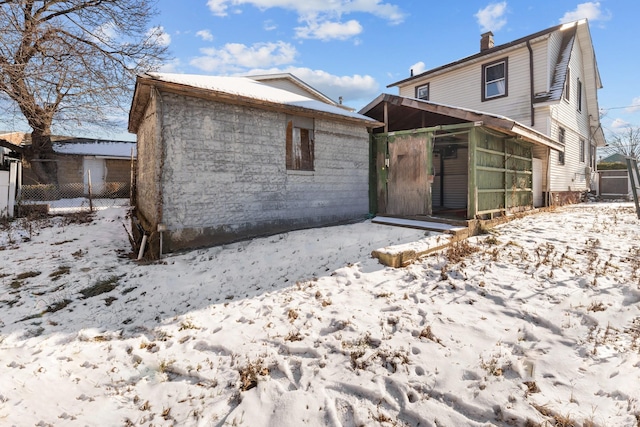 snow covered property featuring an outbuilding