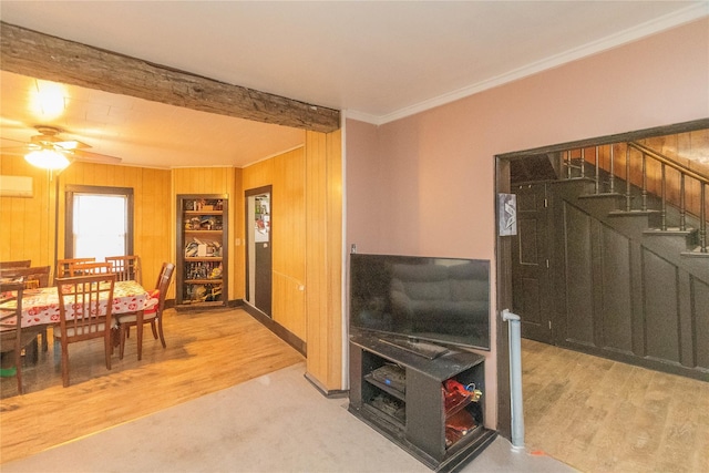 living room featuring ceiling fan, wooden walls, crown molding, a wall mounted air conditioner, and hardwood / wood-style flooring