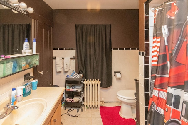 bathroom with radiator heating unit, tile patterned flooring, vanity, tile walls, and toilet