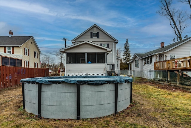 back of house with a yard, a covered pool, and a sunroom