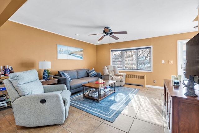 tiled living room featuring ceiling fan and radiator