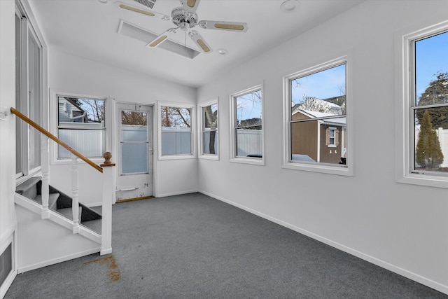 unfurnished sunroom featuring ceiling fan, vaulted ceiling, and a healthy amount of sunlight