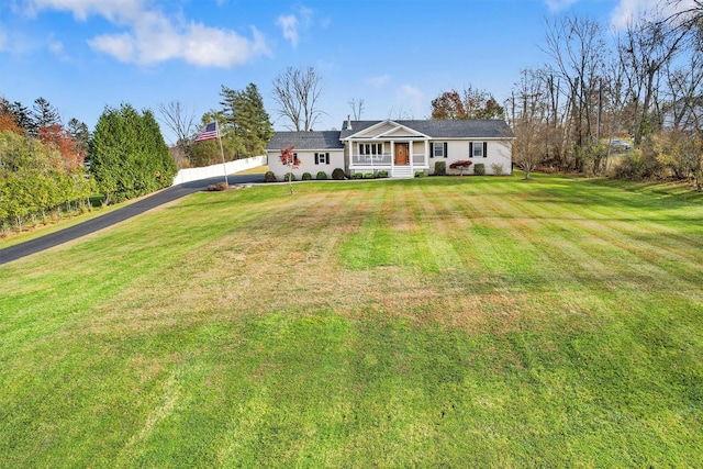 ranch-style home with covered porch and a front yard