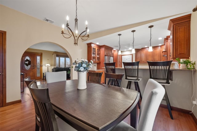 dining room with wood-type flooring and an inviting chandelier