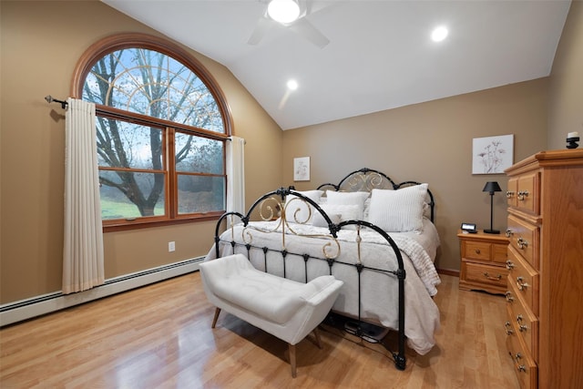 bedroom with ceiling fan, light hardwood / wood-style floors, a baseboard radiator, and lofted ceiling