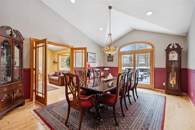 dining area with light wood-type flooring and lofted ceiling