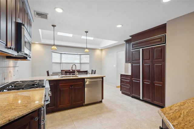 kitchen featuring decorative backsplash, sink, a raised ceiling, pendant lighting, and stainless steel appliances