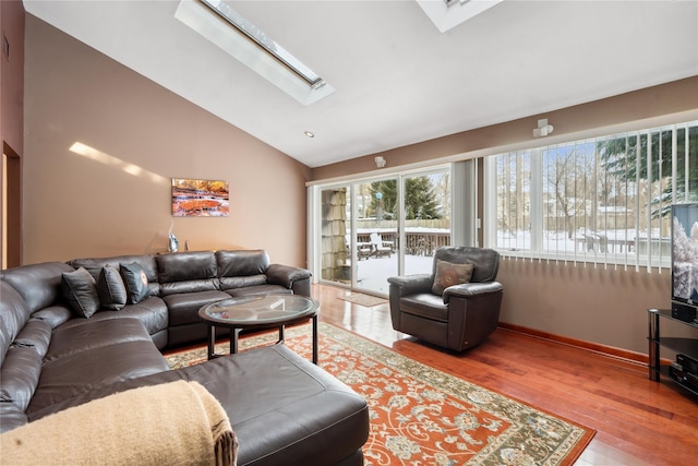 living room featuring hardwood / wood-style flooring and lofted ceiling with skylight