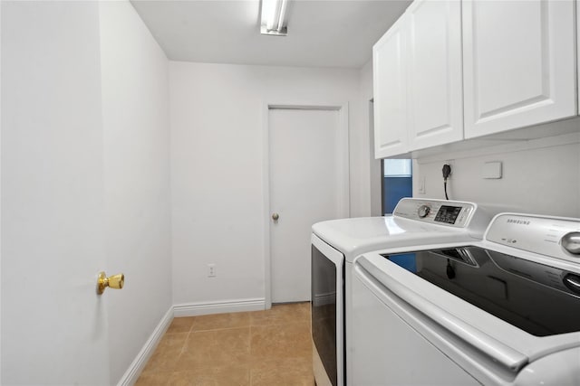 washroom featuring washing machine and clothes dryer, cabinets, and light tile patterned flooring