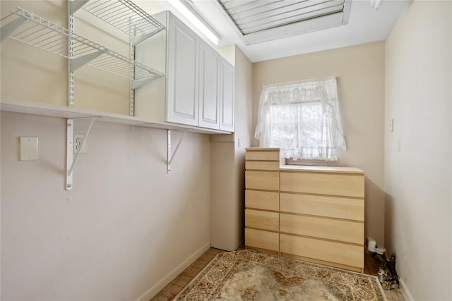 walk in closet with light tile patterned floors