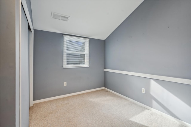 unfurnished room featuring light colored carpet and lofted ceiling