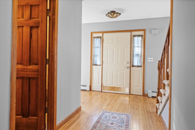 entrance foyer with a baseboard heating unit and light hardwood / wood-style floors