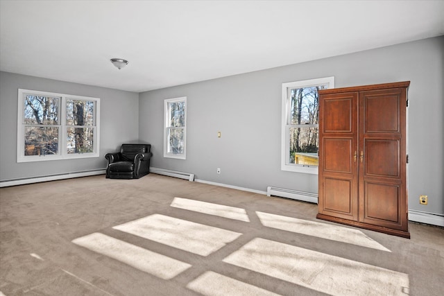 unfurnished room featuring a wealth of natural light, a baseboard heating unit, and light carpet