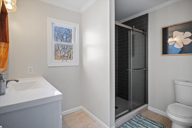 bathroom with toilet, vanity, crown molding, and a shower with shower door