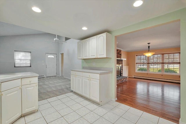 kitchen with a baseboard radiator, decorative light fixtures, light tile patterned flooring, ornamental molding, and white cabinets