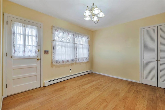 doorway featuring a notable chandelier, light hardwood / wood-style flooring, and a baseboard radiator